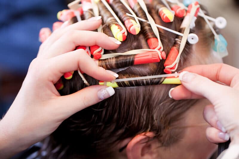 Stylist giving customer a perm.